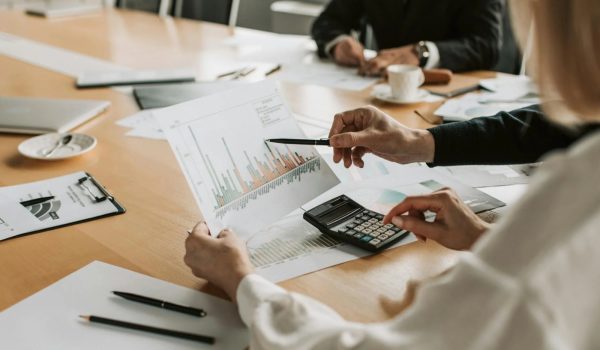 A financial analyst reviewing reports with a laptop and calculator