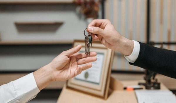 A landlord handing over keys to a new tenant